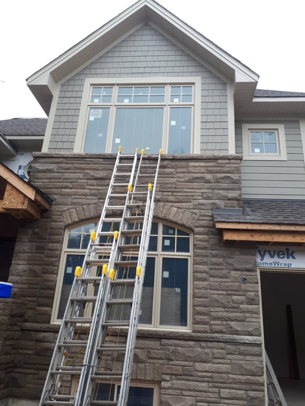 Tall exterior stonework with ladders on site